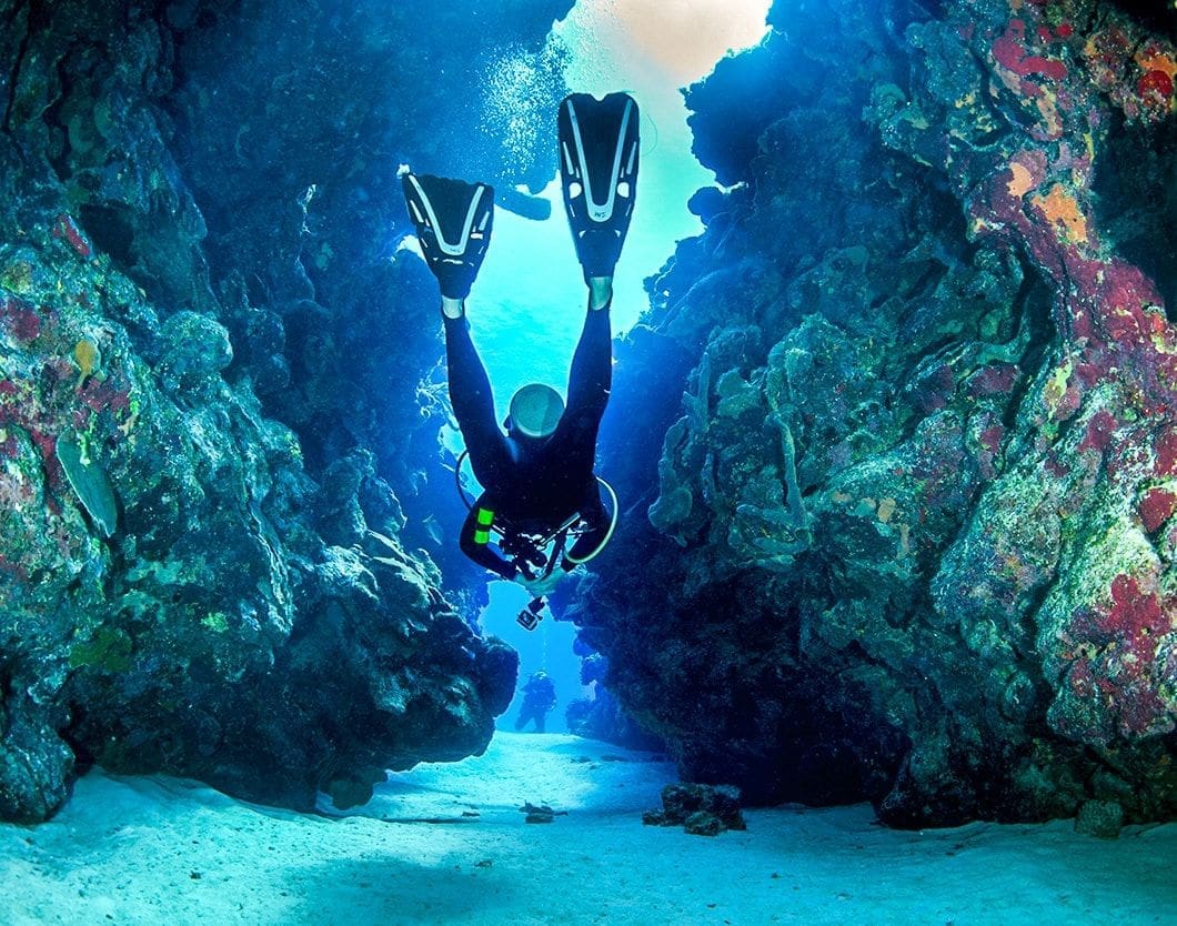 Scuba diver exploring underwater cavern.